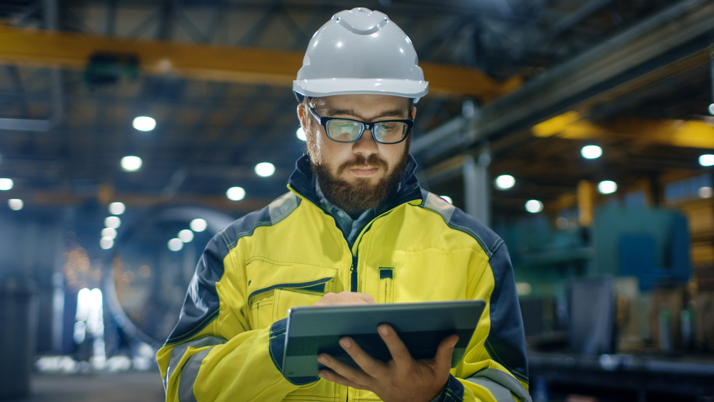 Industrial,Engineer,In,Hard,Hat,Wearing,Safety,Jacket,Uses,Touchscreen