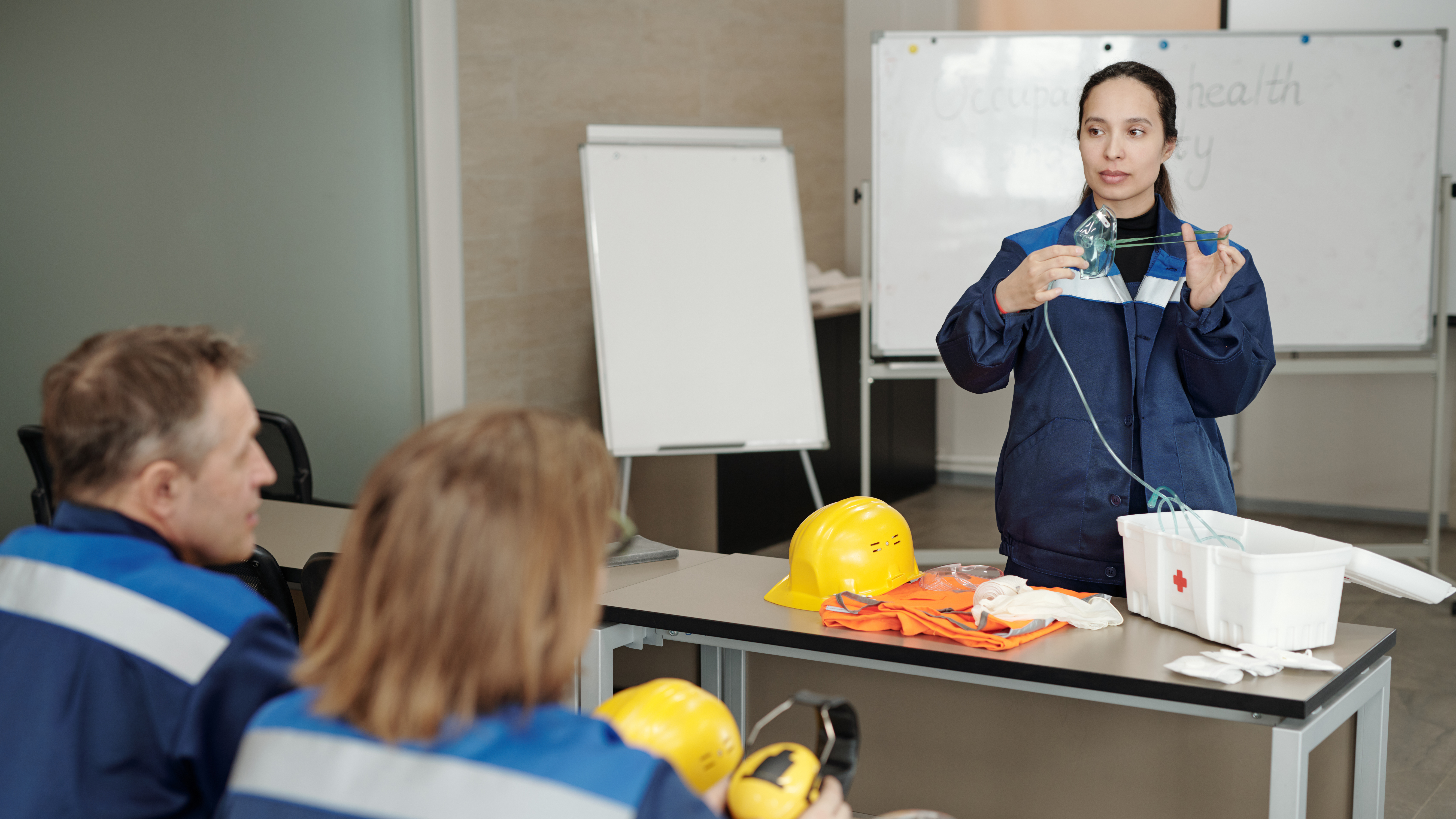 Female worker in blue high visibility outfit delivering safety training to a class