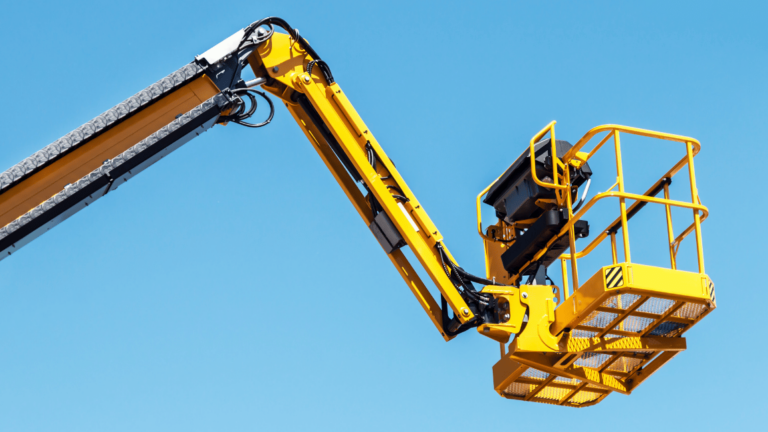 Yellow aerial lift platform extended against a clear blue sky, ideal for illustrating an aerial lift safety toolbox talk focused on equipment handling and fall protection.