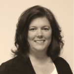 Lynn Benishek smiling and wearing a dark jacket and light colored shirt.