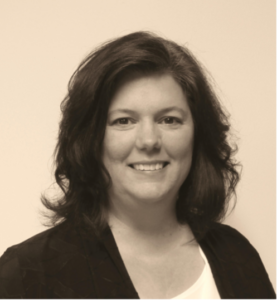 Lynn Benishek smiling and wearing a dark jacket and light colored shirt.