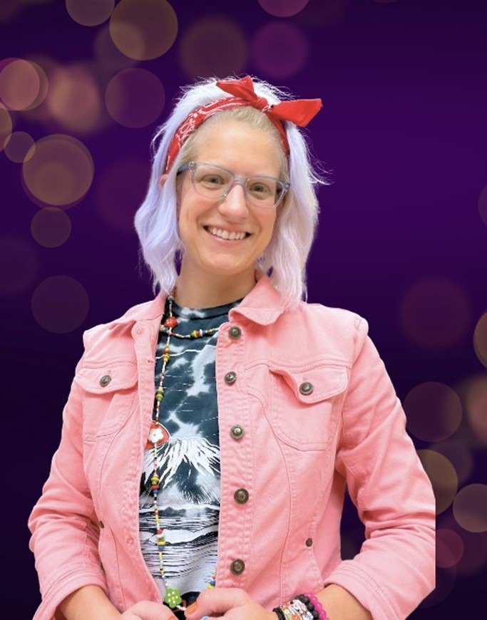 Abby Holovach wearing a pink buttoned jacket and red headband with a purple background.