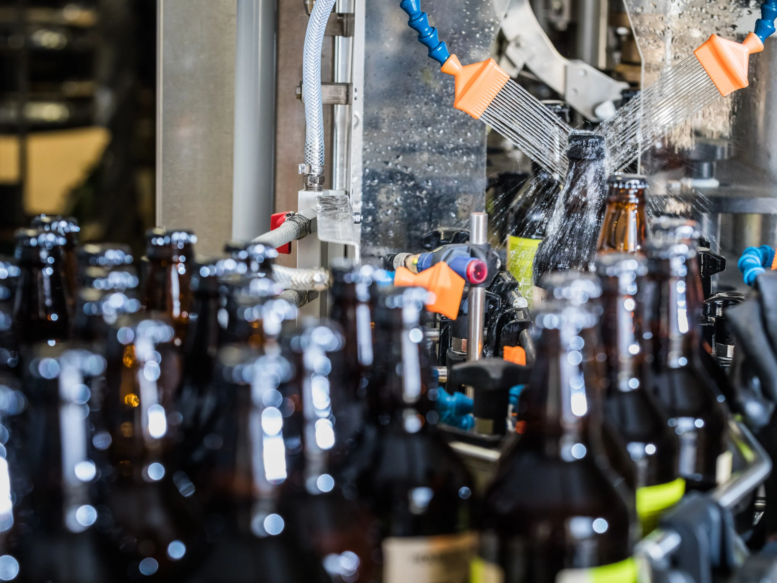 A conveyor belt of brown bottles in a beverage production facility