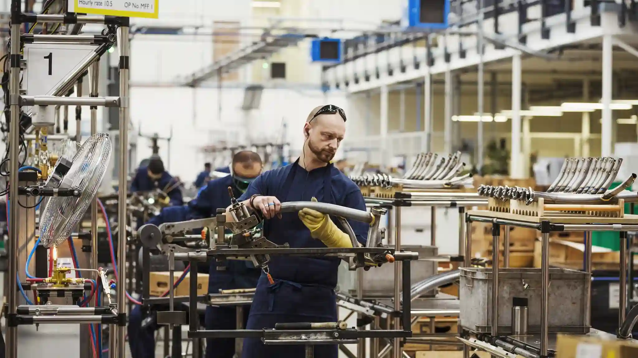 Man in a blue tshirt with a pair of safety glasses on fabricating metal